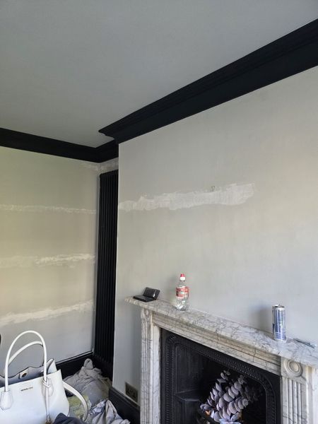 In progress: bedroom with filled and sanded walls around a marble fireplace