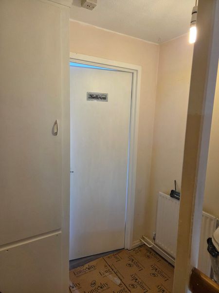 Hallway with a freshly painted white door, frame and walls